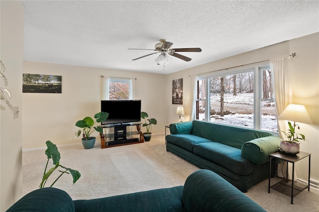 carpeted living room featuring ceiling fan, plenty of natural light, and a textured ceiling