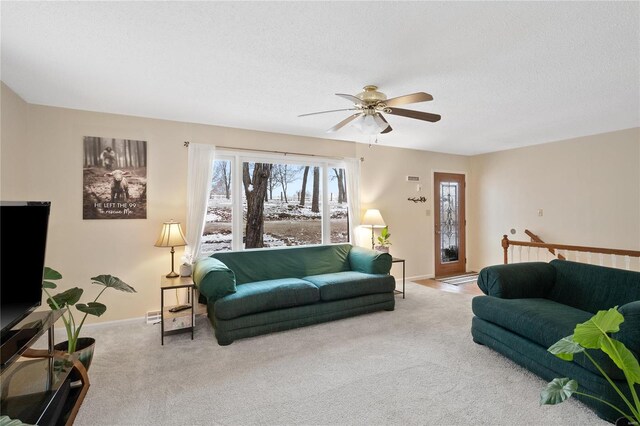 carpeted living room featuring ceiling fan and a textured ceiling