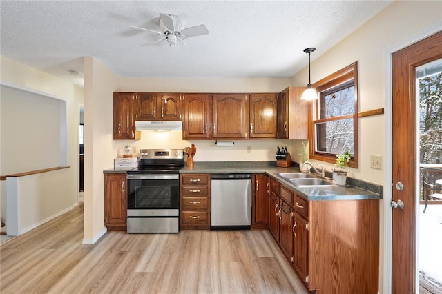 kitchen with a textured ceiling, stainless steel appliances, light hardwood / wood-style floors, and sink