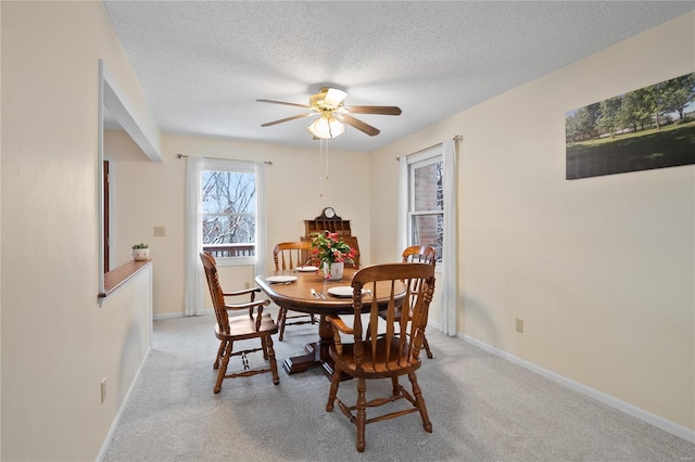 carpeted dining space featuring a textured ceiling and ceiling fan