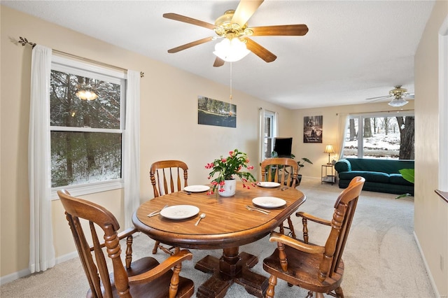 dining area with light colored carpet and ceiling fan