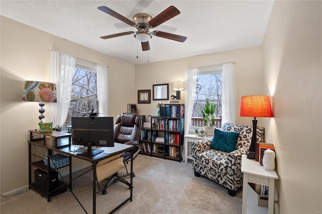 carpeted office featuring ceiling fan and a textured ceiling