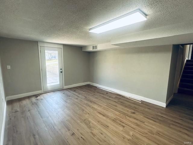 basement with hardwood / wood-style floors and a textured ceiling