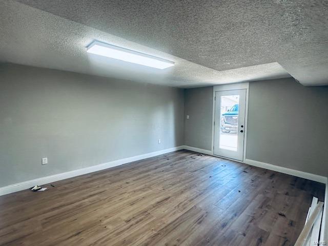 bonus room with hardwood / wood-style floors and a textured ceiling