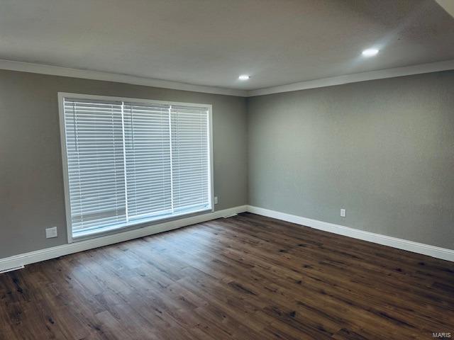 unfurnished room featuring dark hardwood / wood-style floors and ornamental molding