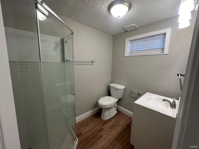 bathroom with hardwood / wood-style floors, vanity, a textured ceiling, and toilet