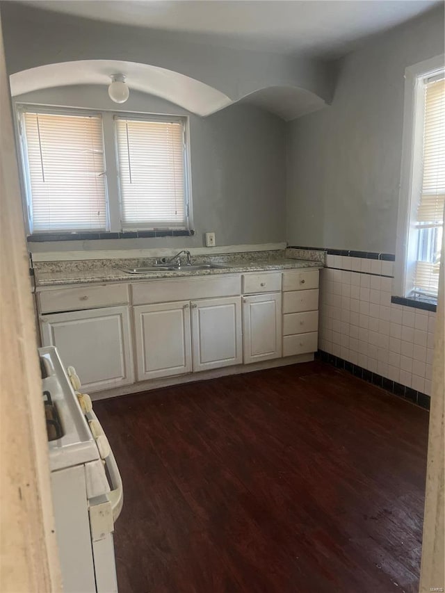 kitchen featuring tile walls, sink, dark wood-type flooring, and white cabinets