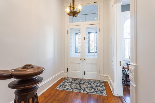 entryway with a notable chandelier, dark hardwood / wood-style flooring, and a wealth of natural light