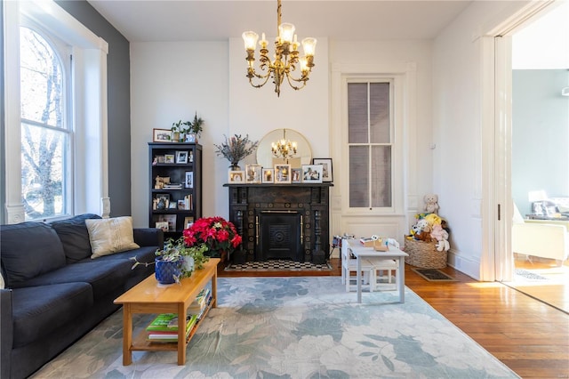 living room featuring wood-type flooring, plenty of natural light, and a notable chandelier