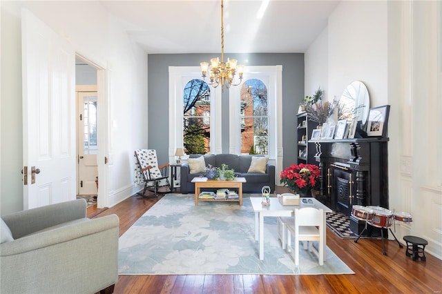 living room featuring wood-type flooring and an inviting chandelier