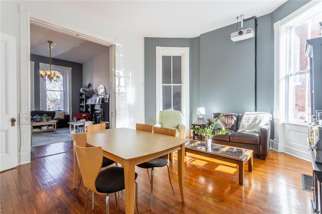 dining room featuring wood-type flooring and an inviting chandelier