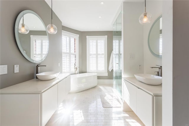 bathroom featuring tile patterned flooring, vanity, and a tub to relax in