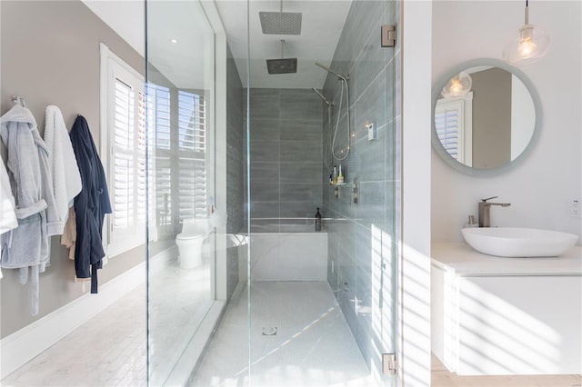 bathroom with vanity, toilet, and a shower with door