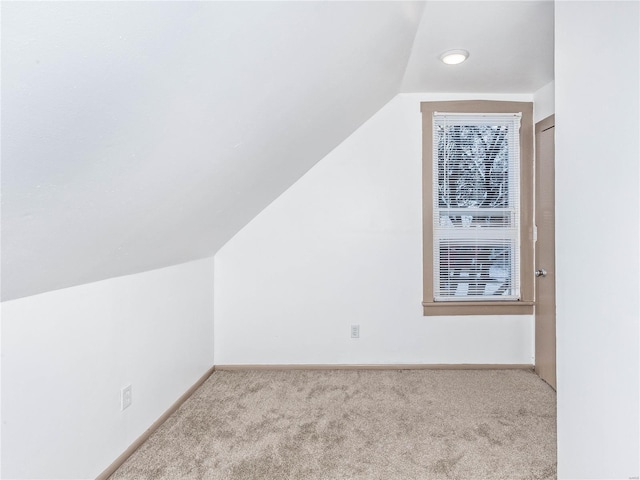 additional living space with light colored carpet and lofted ceiling