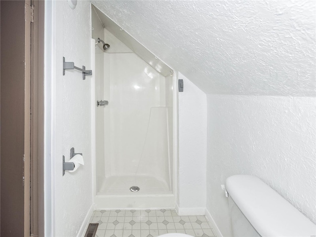 bathroom with toilet, a shower, a textured ceiling, and vaulted ceiling