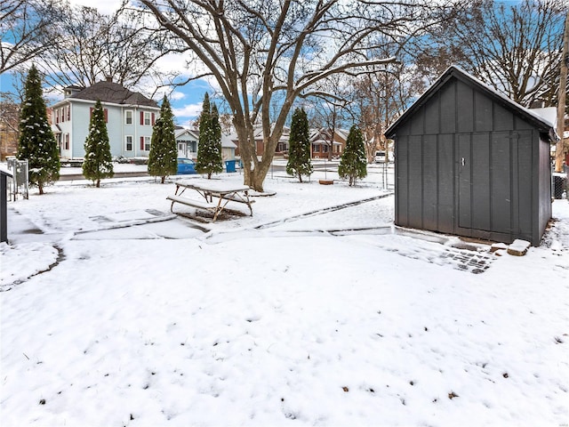 yard layered in snow with a storage unit