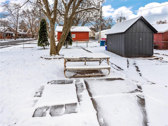 yard layered in snow with a storage shed