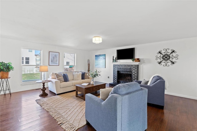 living room with dark hardwood / wood-style flooring and a brick fireplace