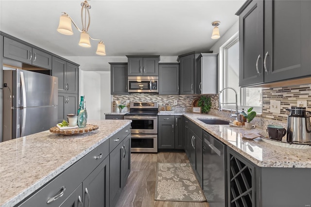 kitchen with sink, stainless steel appliances, dark hardwood / wood-style floors, decorative light fixtures, and decorative backsplash