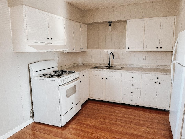 kitchen with white appliances, dark hardwood / wood-style floors, white cabinetry, and sink