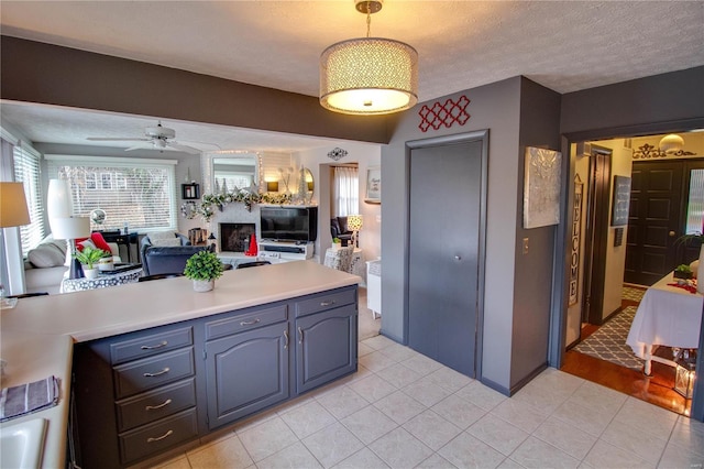 kitchen featuring ceiling fan, light tile patterned floors, and a textured ceiling