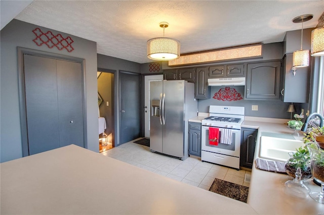 kitchen featuring sink, stainless steel fridge, a textured ceiling, decorative light fixtures, and white range with gas cooktop