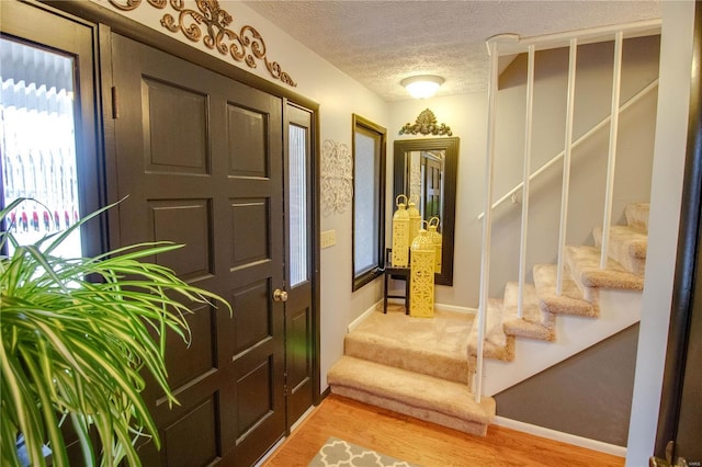 entrance foyer featuring a textured ceiling and hardwood / wood-style flooring