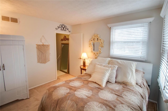 bedroom with light carpet and a textured ceiling