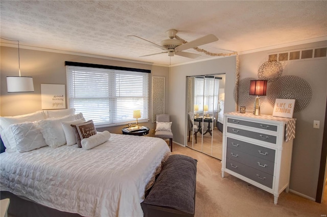 bedroom featuring a textured ceiling, ceiling fan, light colored carpet, and crown molding