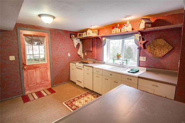 kitchen featuring light carpet, sink, and white stove