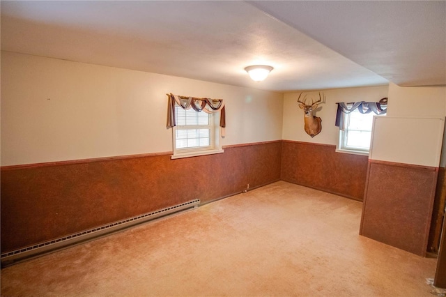 carpeted empty room with a baseboard heating unit