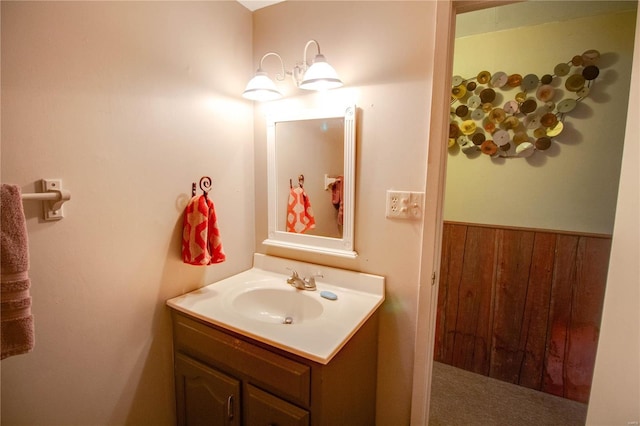 bathroom featuring vanity and wood walls