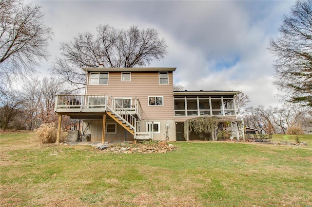 back of property with a sunroom, a deck, and a yard