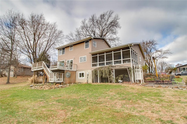 back of property featuring a sunroom, a deck, and a yard