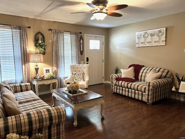 living room with ceiling fan, dark hardwood / wood-style flooring, and a textured ceiling