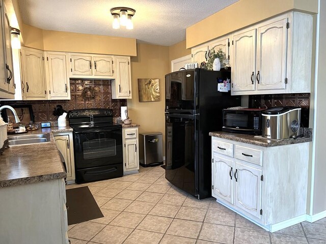 kitchen featuring backsplash, black appliances, sink, light tile patterned floors, and a textured ceiling