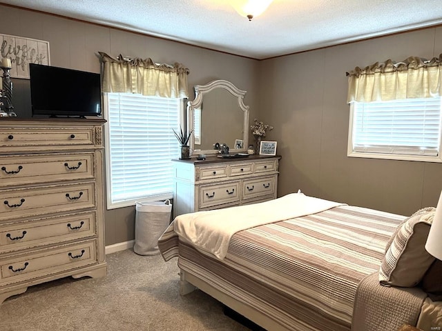 bedroom featuring multiple windows, light colored carpet, and a textured ceiling