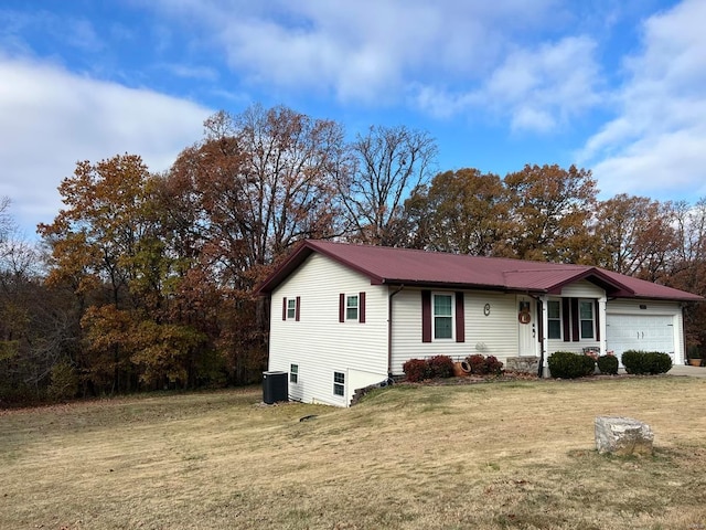 view of front of home featuring a garage, central air condition unit, and a front yard