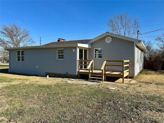 rear view of property featuring a yard and a deck