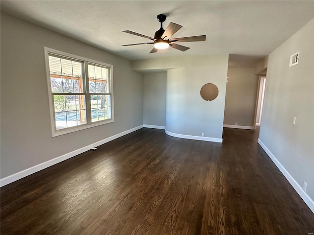 spare room featuring dark wood-type flooring, a textured ceiling, and ceiling fan