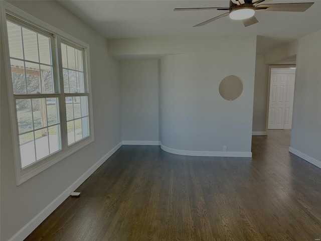 empty room featuring dark wood-type flooring and ceiling fan