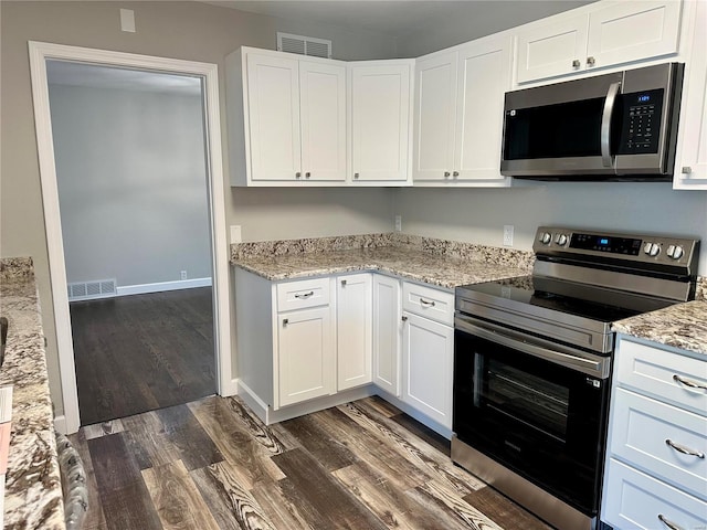 kitchen with stainless steel appliances, white cabinetry, dark hardwood / wood-style floors, and light stone counters