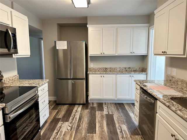 kitchen with white cabinetry, stainless steel appliances, and light stone counters