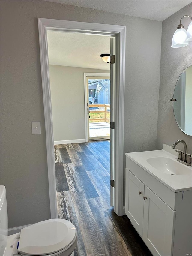 bathroom featuring hardwood / wood-style flooring, vanity, and toilet