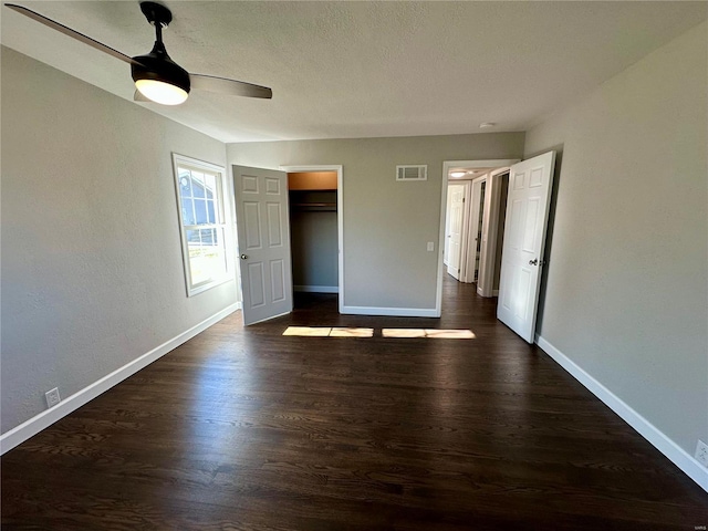 unfurnished bedroom featuring ceiling fan, dark hardwood / wood-style flooring, and a textured ceiling