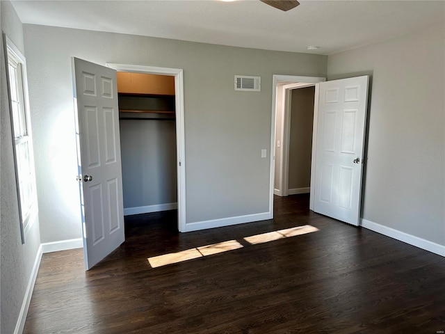 unfurnished bedroom with dark hardwood / wood-style flooring and a closet