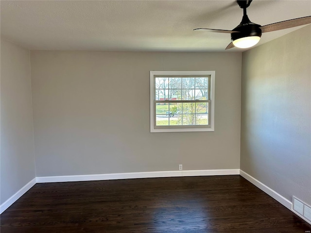 spare room with dark hardwood / wood-style floors, a textured ceiling, and ceiling fan