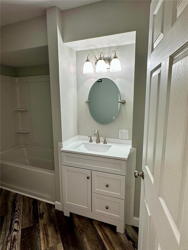 bathroom featuring hardwood / wood-style flooring, vanity, and shower / bathing tub combination