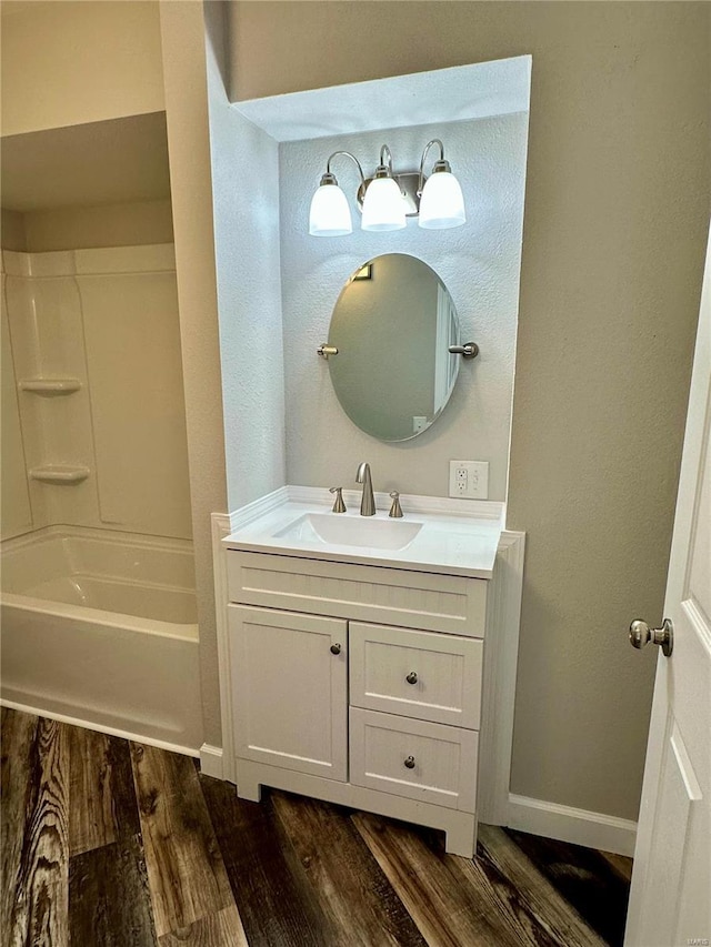 bathroom with wood-type flooring, bathing tub / shower combination, and vanity