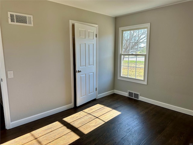 empty room with dark hardwood / wood-style flooring